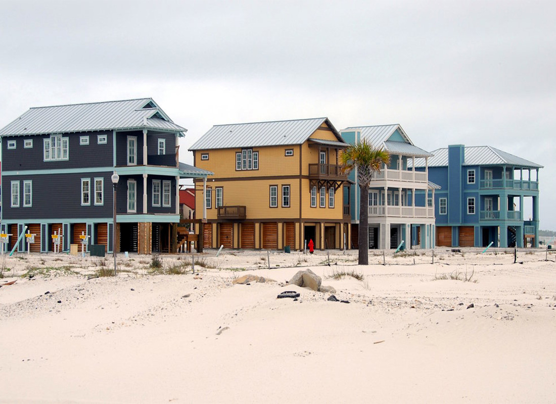 Elevated homes on wood pilings above white sand on the Florida Gulf coast